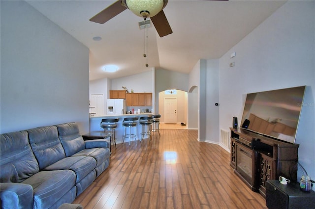 3684 Madbury Cir, Lakeland, FL 33810 - living room featuring arched walkways, vaulted ceiling, visible vents, a ceiling fan, and hardwood / wood-style flooring