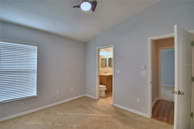 3684 Madbury Cir, Lakeland, FL 33810 - unfurnished bedroom featuring a sink, vaulted ceiling, baseboards, ensuite bath, and carpet floors