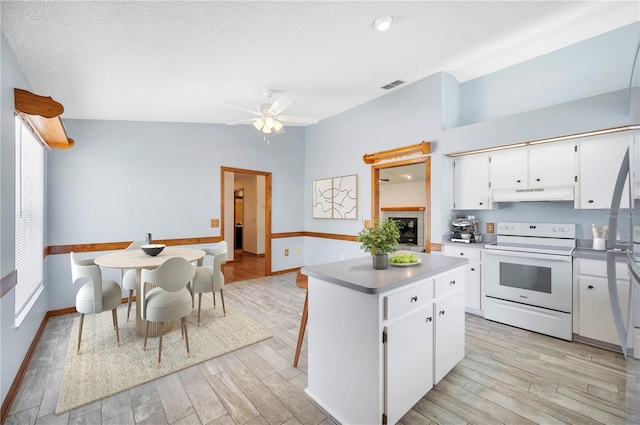 3226 Cherry Hill Cir S, Lakeland, FL 33810 - kitchen featuring visible vents, a center island, baseboards, white range with electric stovetop, and under cabinet range hood