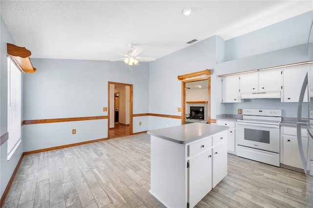 3226 Cherry Hill Cir S, Lakeland, FL 33810 - kitchen with light wood finished floors, a center island, under cabinet range hood, visible vents, and white electric range