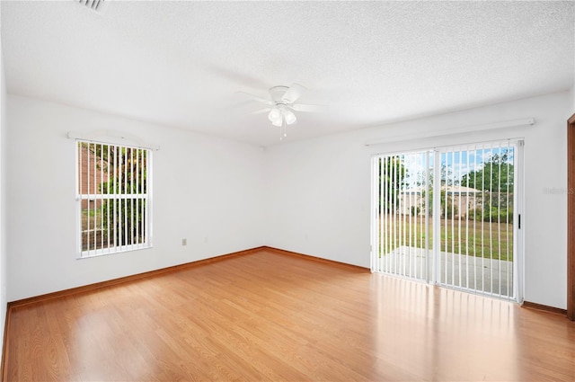 3226 Cherry Hill Cir S, Lakeland, FL 33810 - empty room featuring a textured ceiling, baseboards, a ceiling fan, and wood finished floors