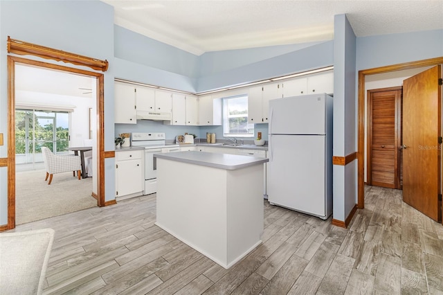 3226 Cherry Hill Cir S, Lakeland, FL 33810 - kitchen with white appliances, under cabinet range hood, light countertops, light wood-style flooring, and vaulted ceiling
