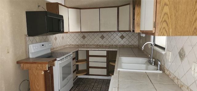 kitchen with black microwave, tile counters, a sink, and white range with electric cooktop