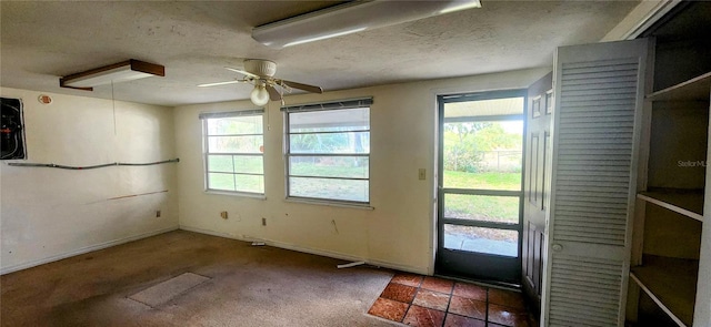 doorway featuring ceiling fan, baseboards, carpet flooring, and a textured ceiling