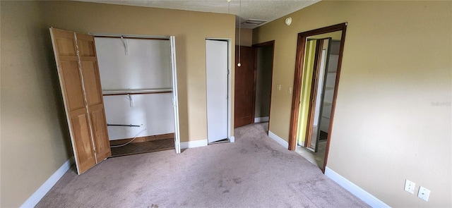 unfurnished bedroom featuring carpet, visible vents, baseboards, and two closets