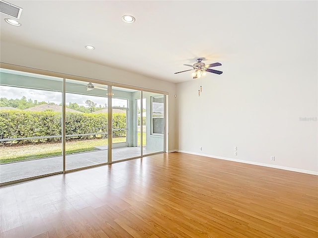 spare room with light wood-style floors, baseboards, a ceiling fan, and visible vents