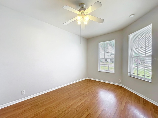 spare room featuring baseboards, ceiling fan, and wood finished floors