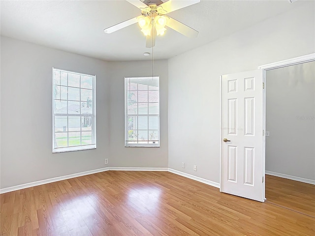 spare room with a ceiling fan, baseboards, and light wood-style floors