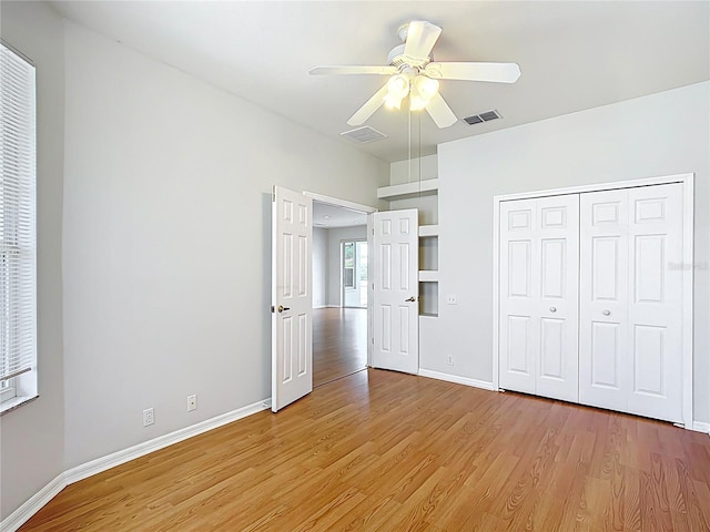 unfurnished bedroom featuring baseboards, light wood-style flooring, and visible vents