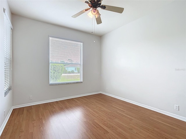 empty room featuring baseboards, ceiling fan, and wood finished floors