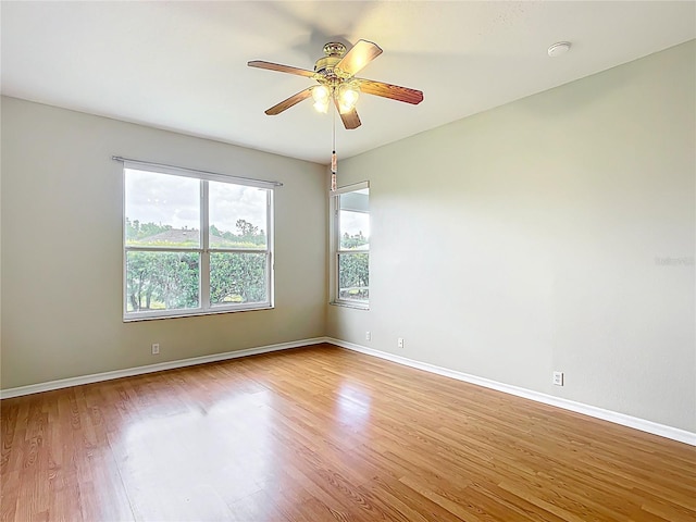 spare room featuring baseboards, ceiling fan, and wood finished floors