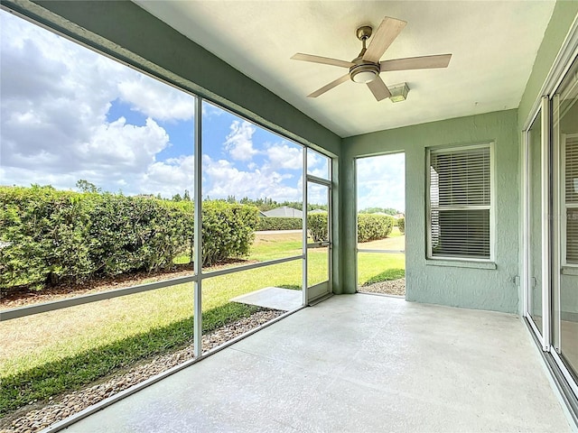 unfurnished sunroom featuring a ceiling fan