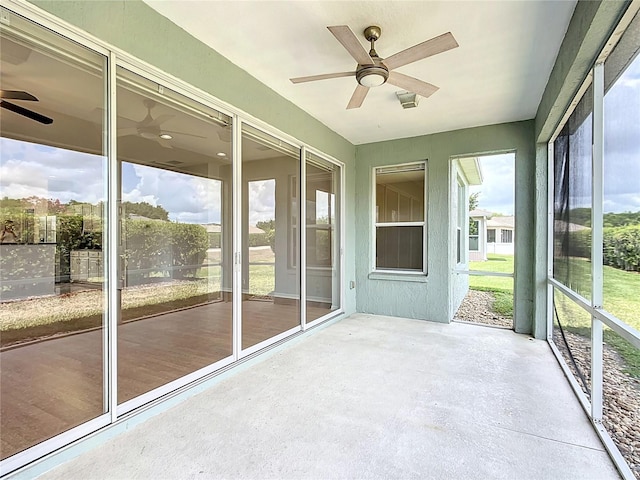 unfurnished sunroom featuring a ceiling fan