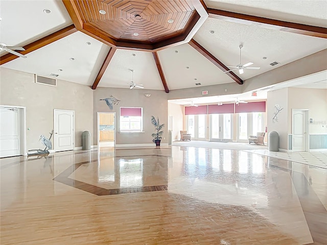 interior space featuring baseboards, ceiling fan, a healthy amount of sunlight, and high vaulted ceiling