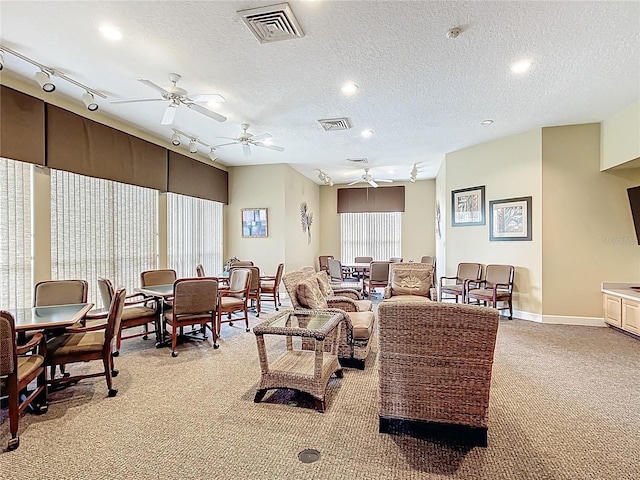 living area with ceiling fan, light colored carpet, baseboards, and visible vents