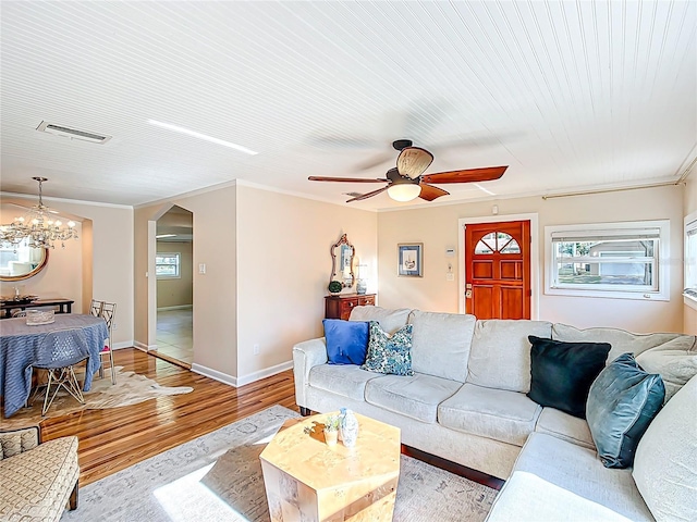 737 Kensington St, Lakeland, FL 33803 - living room featuring arched walkways, light wood-style flooring, ornamental molding, ceiling fan with notable chandelier, and visible vents