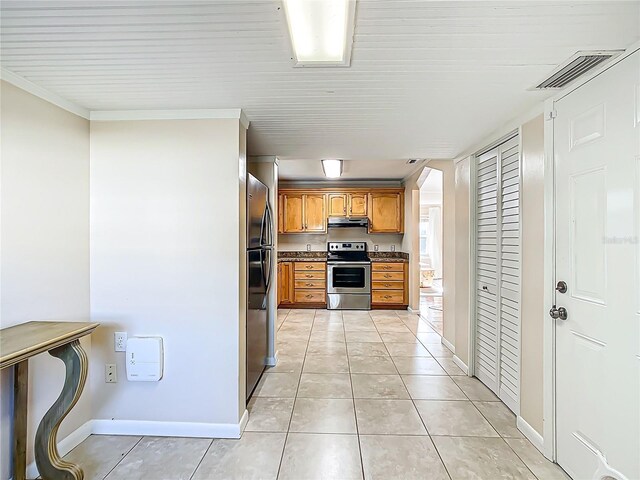 737 Kensington St, Lakeland, FL 33803 - kitchen with stainless steel appliances, under cabinet range hood, light tile patterned floors, brown cabinetry, and visible vents