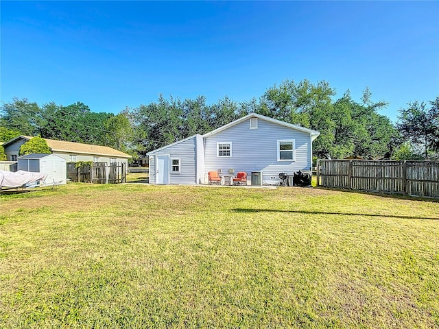 737 Kensington St, Lakeland, FL 33803 - rear view of house featuring an outbuilding, a storage shed, a yard, and fence