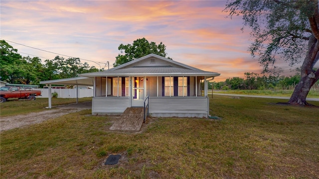 410 Orange St, Bradley, FL 33835 - view of front of house featuring driveway, fence, a carport, and a lawn