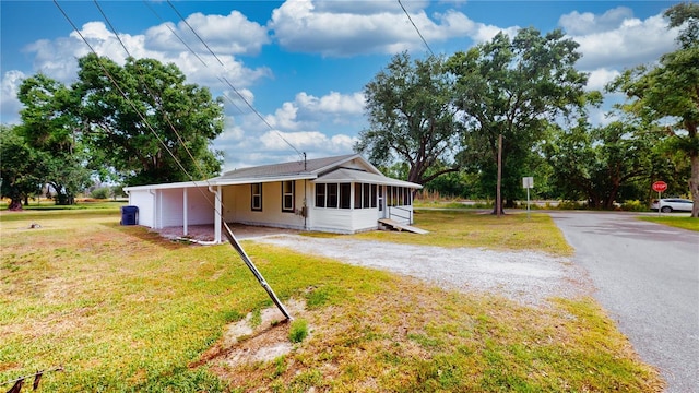 410 Orange St, Bradley, FL 33835 - view of front of house featuring a sunroom, driveway, a front yard, and an attached carport