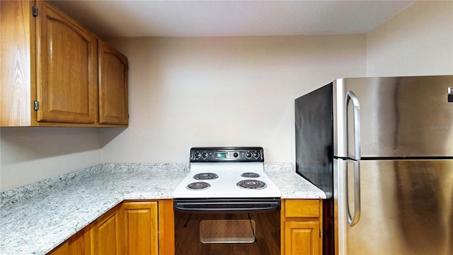 410 Orange St, Bradley, FL 33835 - kitchen with range with electric stovetop, freestanding refrigerator, and brown cabinets