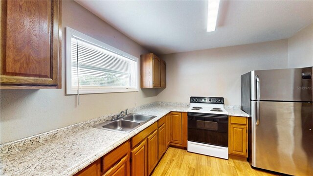 410 Orange St, Bradley, FL 33835 - kitchen with light wood finished floors, light countertops, a sink, freestanding refrigerator, and electric range