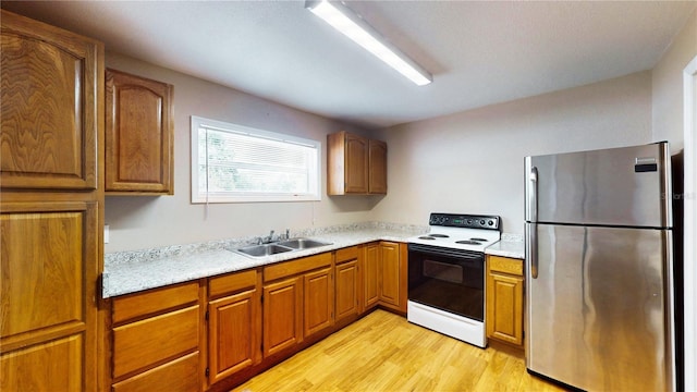 410 Orange St, Bradley, FL 33835 - kitchen with electric stove, a sink, light wood-style floors, light countertops, and freestanding refrigerator