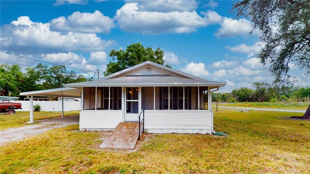 410 Orange St, Bradley, FL 33835 - view of front facade with fence, a front lawn, driveway, a carport, and a sunroom