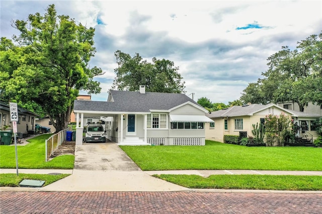 422 E Belmar St, Lakeland, FL 33803 - bungalow-style home featuring a front lawn, roof with shingles, a chimney, an attached carport, and driveway