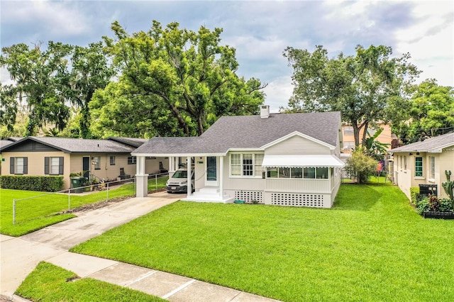 422 E Belmar St, Lakeland, FL 33803 - view of front of house with concrete driveway, a shingled roof, an attached carport, and a front lawn
