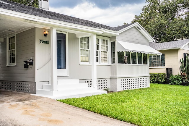 422 E Belmar St, Lakeland, FL 33803 - property entrance featuring a lawn, crawl space, a chimney, and roof with shingles