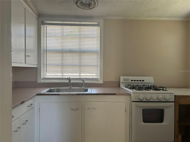 422 E Belmar St, Lakeland, FL 33803 - kitchen featuring white cabinets, a textured ceiling, white gas stove, and a sink