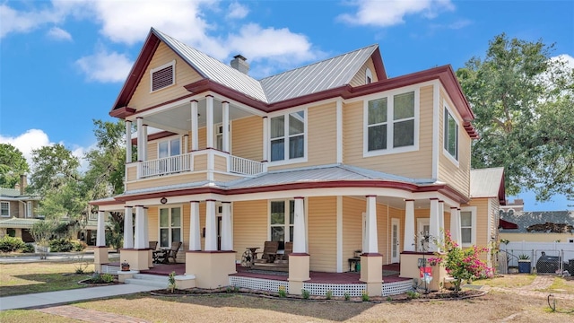 410 S Broadway Ave, Bartow, FL 33830 - victorian house featuring a porch, a chimney, metal roof, fence, and a balcony
