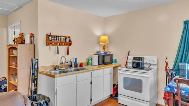 410 S Broadway Ave, Bartow, FL 33830 - kitchen featuring electric stove, a sink, light countertops, white cabinetry, and black microwave