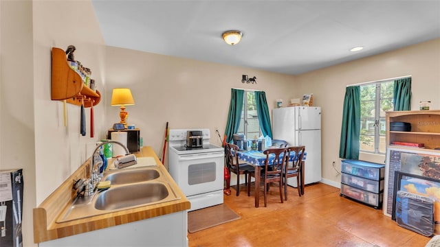 410 S Broadway Ave, Bartow, FL 33830 - kitchen featuring white appliances, a sink, light wood-style flooring, and recessed lighting