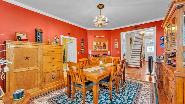 410 S Broadway Ave, Bartow, FL 33830 - dining room featuring a chandelier, light wood-style flooring, crown molding, and stairs