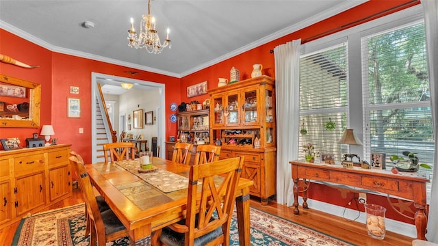 410 S Broadway Ave, Bartow, FL 33830 - dining space featuring light wood-style floors, a chandelier, plenty of natural light, crown molding, and stairs