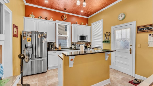 410 S Broadway Ave, Bartow, FL 33830 - kitchen featuring stainless steel appliances, white cabinets, an ornate ceiling, a center island, and a kitchen bar
