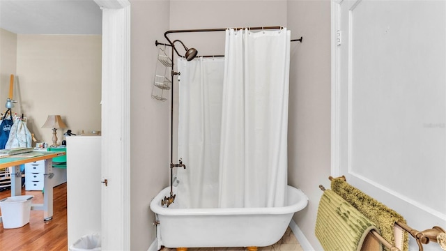 410 S Broadway Ave, Bartow, FL 33830 - bathroom featuring a soaking tub, a shower with shower curtain, and wood finished floors