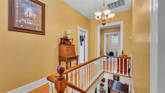 410 S Broadway Ave, Bartow, FL 33830 - hallway featuring an upstairs landing, baseboards, a chandelier, and wood finished floors