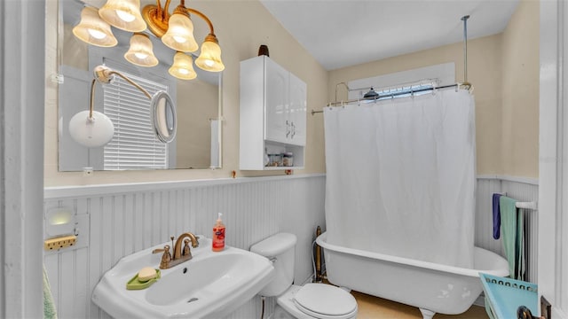 410 S Broadway Ave, Bartow, FL 33830 - bathroom featuring a sink, a soaking tub, a wainscoted wall, toilet, and curtained shower