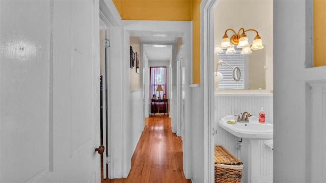 410 S Broadway Ave, Bartow, FL 33830 - hallway with a wainscoted wall, wood finished floors, a chandelier, and a sink