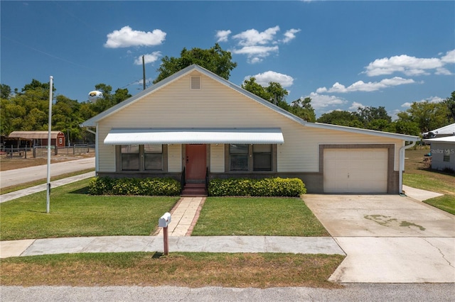 view of front of home featuring a garage, concrete driveway, and a front yard
