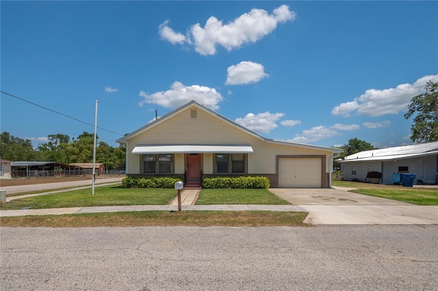 view of front of house featuring an attached garage, concrete driveway, and a front yard