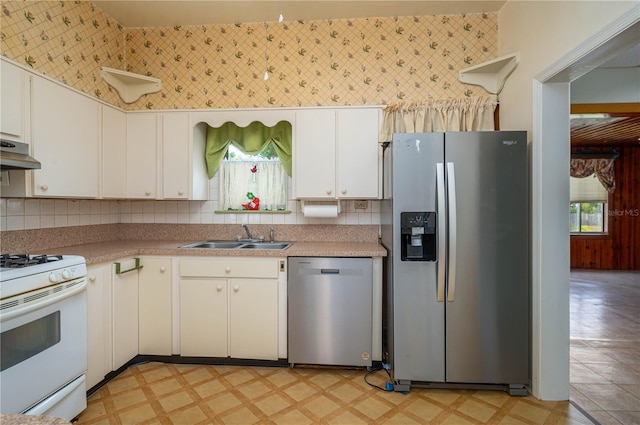 kitchen featuring a sink, appliances with stainless steel finishes, plenty of natural light, and light floors