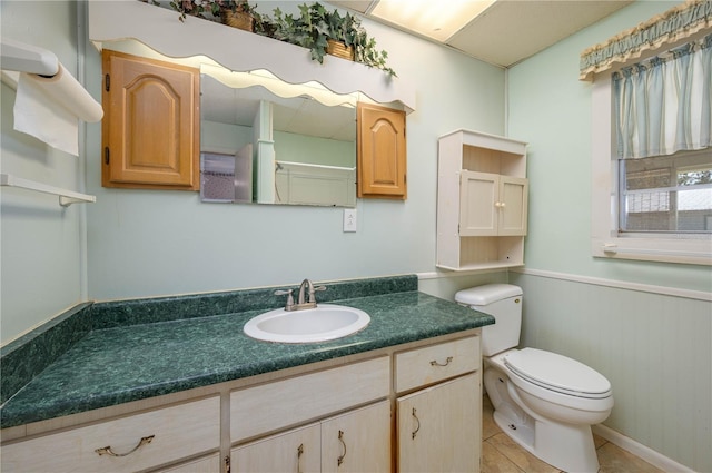 full bathroom with tile patterned flooring, wainscoting, vanity, toilet, and wooden walls
