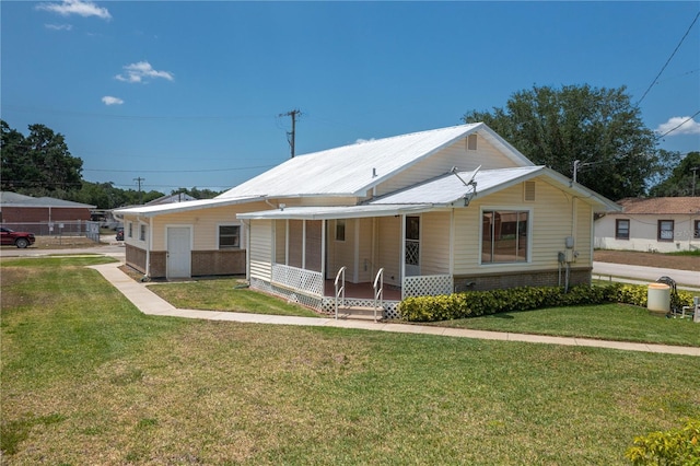 view of front of home with covered porch, brick siding, and a front yard