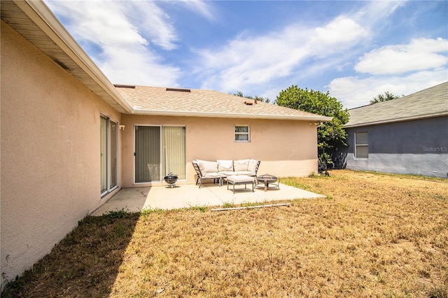 exterior space featuring outdoor lounge area, stucco siding, a lawn, and a patio area