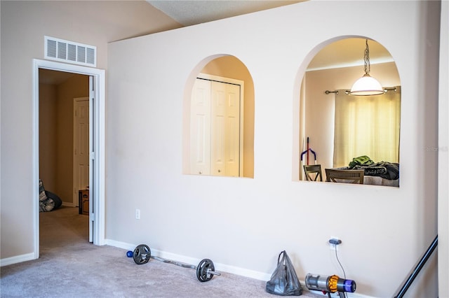 interior space featuring visible vents, arched walkways, and baseboards