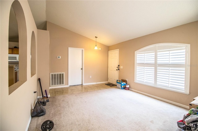 interior space featuring arched walkways, visible vents, lofted ceiling, and baseboards